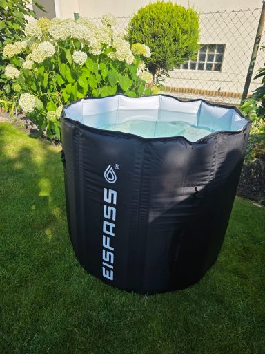 Aufblasbares, rundes Planschbecken in einem Garten mit grüner Rasenfläche und Pflanzen.