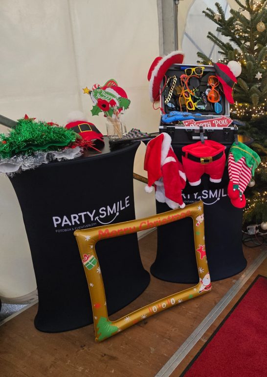 Weihnachtliche Dekorationen und Verkleidungen auf einem Tisch mit einem Rahmen.