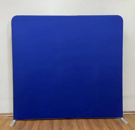 Blauer, gepolsterter Raumteiler mit stabilen Metallfüßen auf einem Holzfußboden.